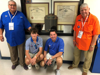 A family gathering in front of the Marshall Scholarship display in Weil Hall. From left to right, Bryant Marshall, Colin Addison Marshall, Graham Colin Marshall (Colin’s father) and Frank Marshall (Graham’s father).